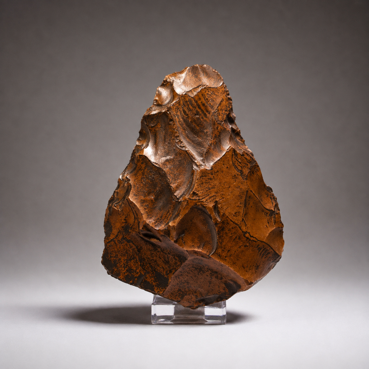 Pieza de silueta subtriangular ancha, con aristas laterales bien definidas sobre cuarcita ferruginosa. Presenta una marcada pátina de intemperismo eólico en tonos rojizos.