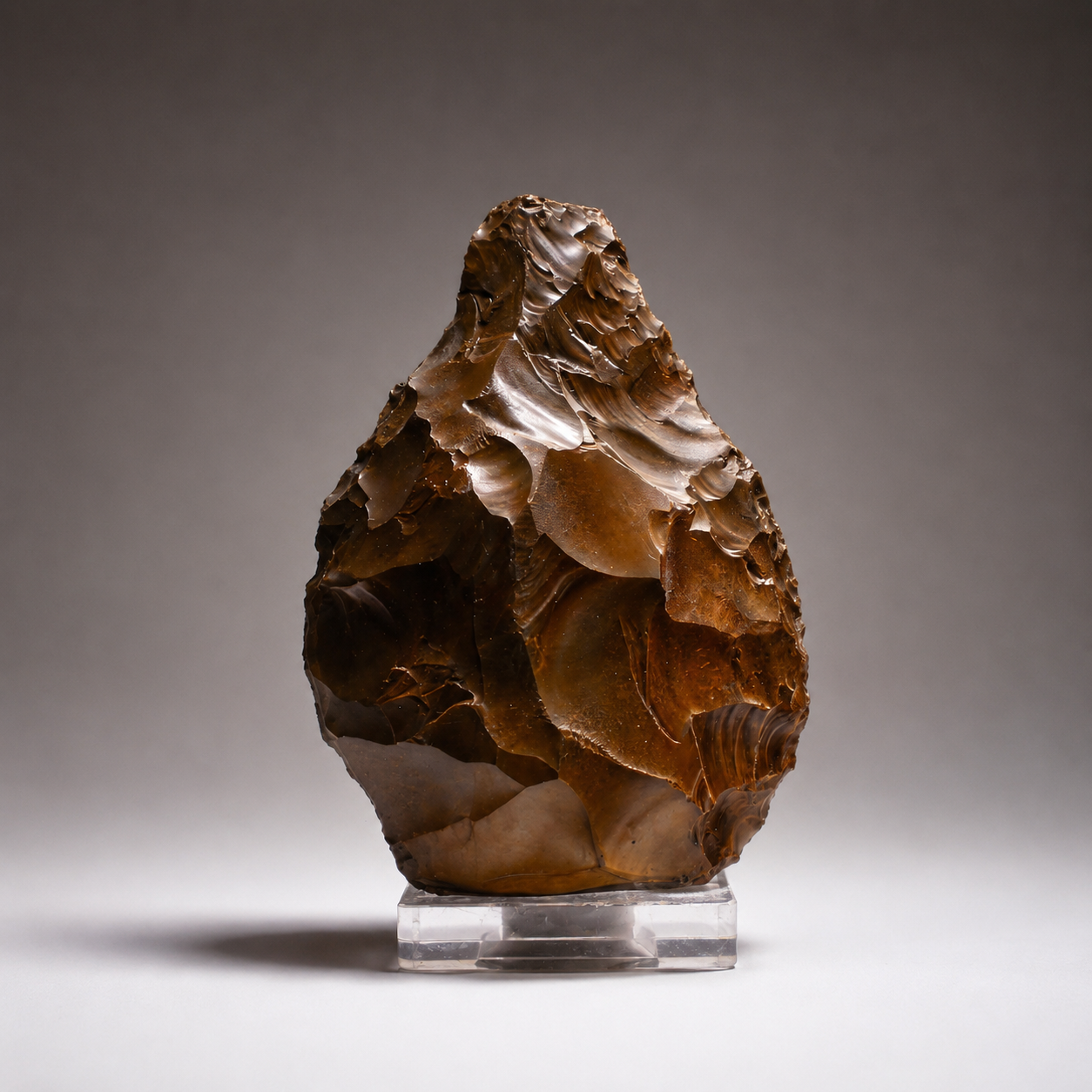 Bifaz de silueta sub-triangular estilizada, con retoque bifacial y talón tallado. Presenta un pulido eólico característico («barniz del desierto») en tono marrón oscuro radiante.