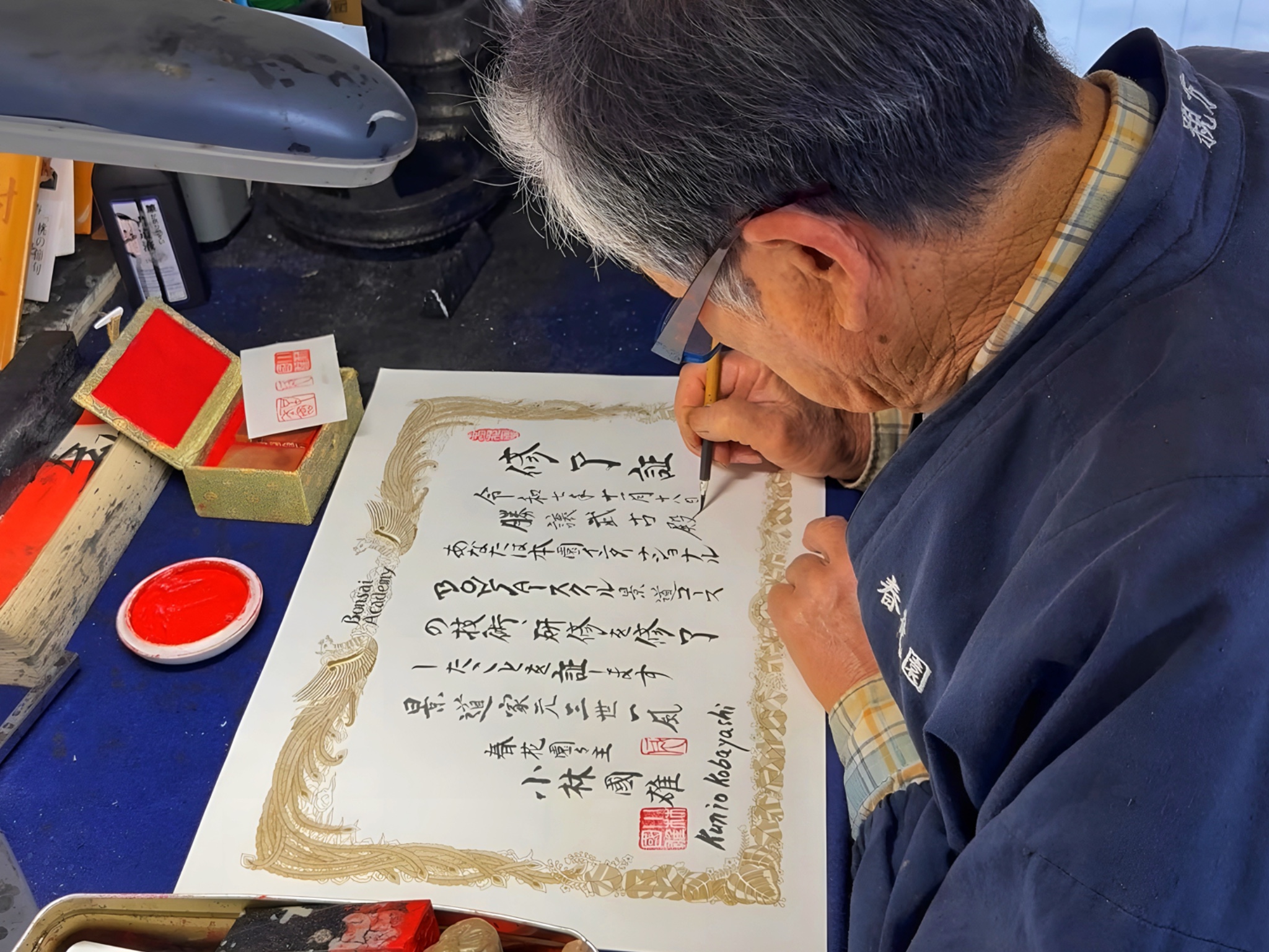 Kobayashi Ippū caligrafiando a mano con pincel y tinta el diploma de finalización Nº1 de Marcial Yuste Blasco, con más de 60 kanji y cuatro hanko