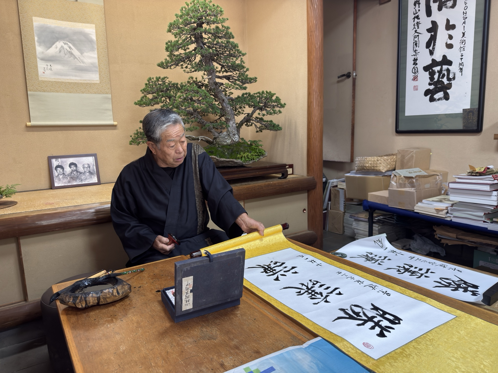 El III Iemoto Kobayashi Ippū, con el hanko en la mano, ante el kakejiku ya escrito
