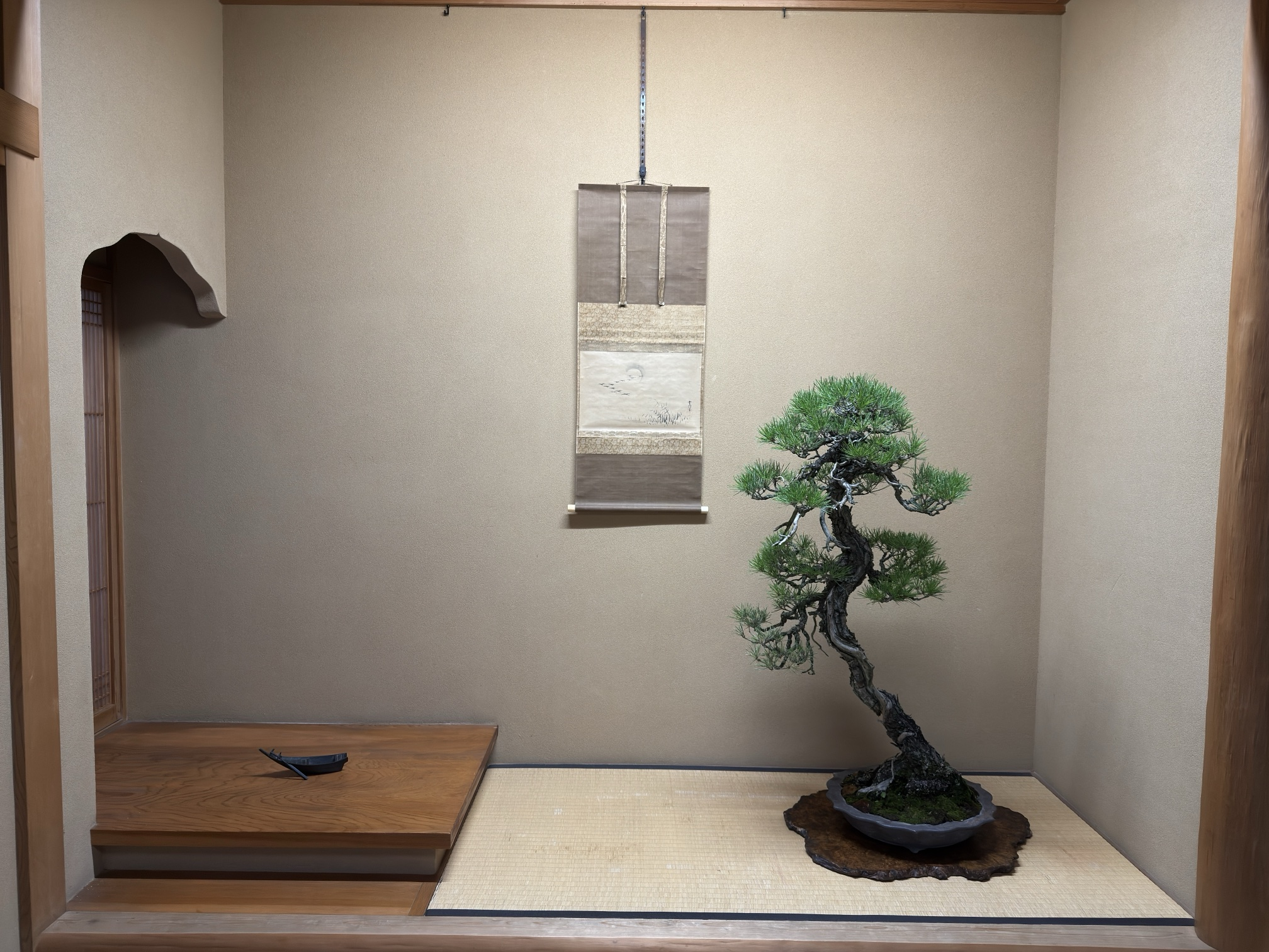 Kuromatsu de estilo bunjin sobre una ita de madera en un tokonoma, con un kakejiku de gansos y un tenkei de cobre con forma de barca