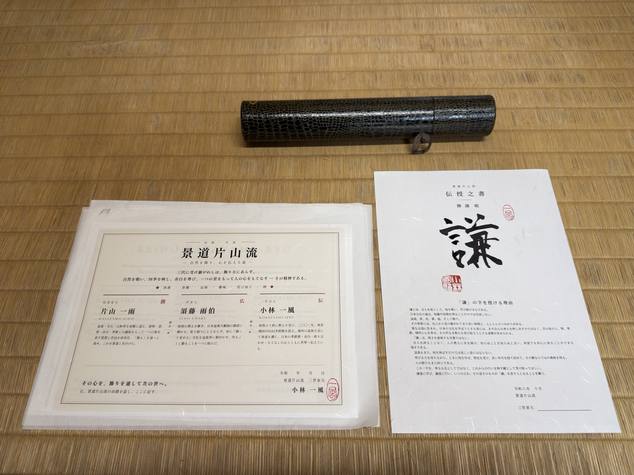 Documento de genealogía de la escuela y documento de transmisión 伝授之書 junto al estuche, sobre tatami