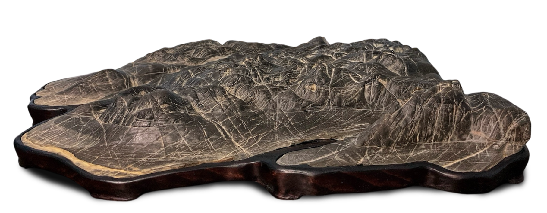Suiseki con una cumbre central pronunciada flanqueada por crestas menores, sobre daiza de madera · colección de Marcial Yuste Blasco